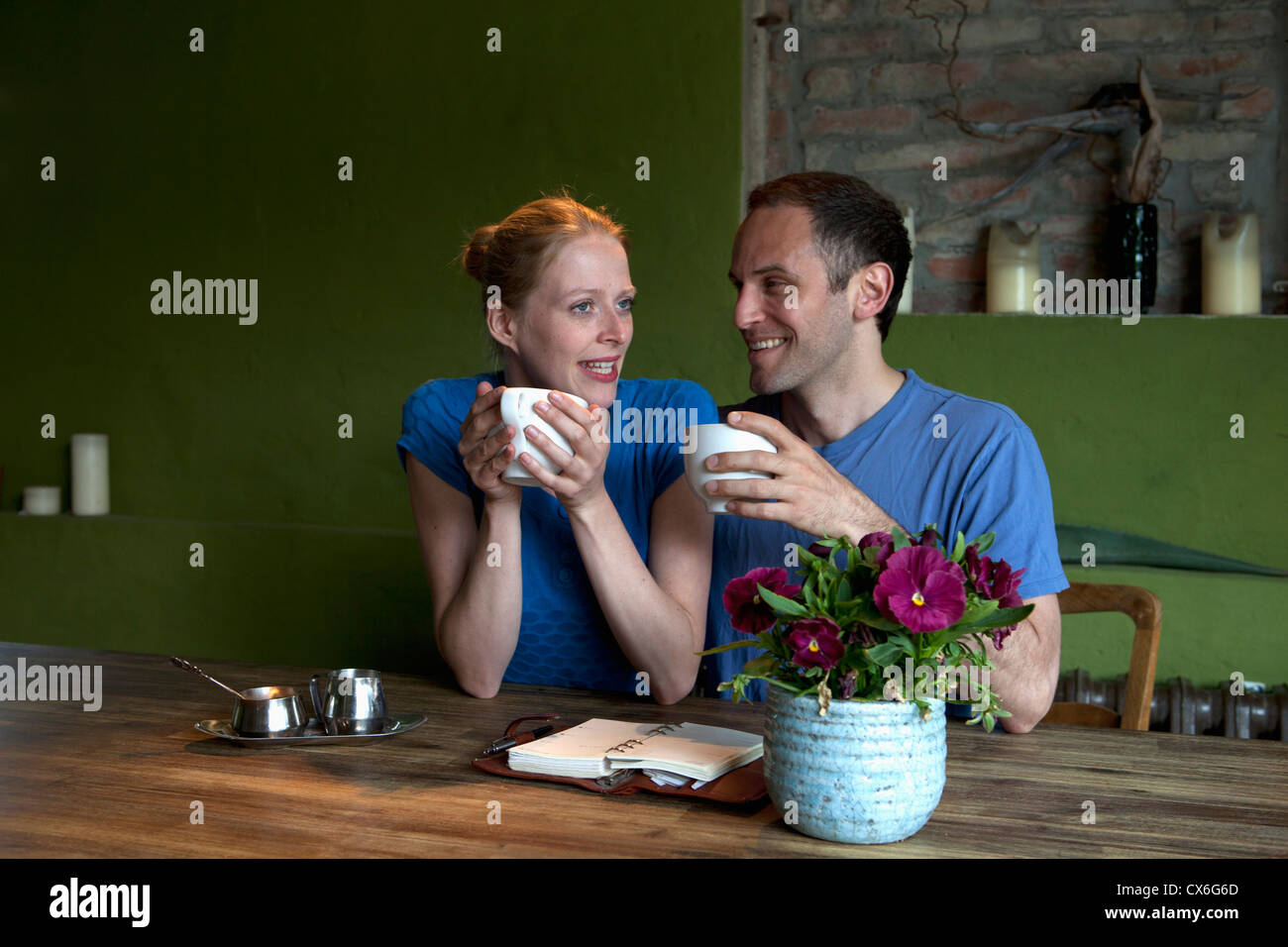 Ein paar sitzt am Esstisch mit ein persönlicher Organizer, sprechen über Kaffee Stockfoto