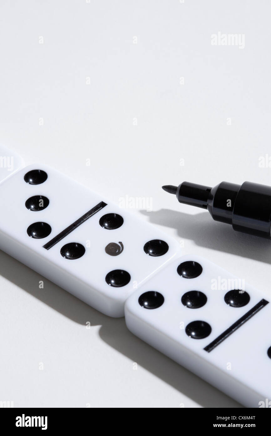 Ein Domino mit einem gefälschten Punkt drauf, Filzstift Marker in der Nähe Stockfoto