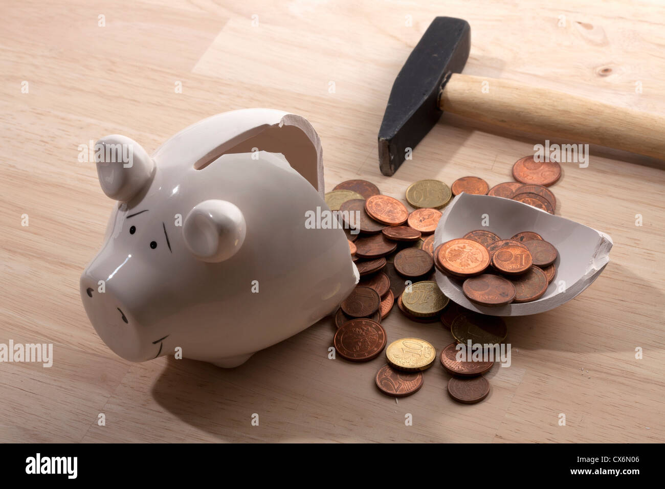 Ein Hammer liegen neben einem gebrochenen Sparschwein mit Euro-Münzen verschütten Stockfoto