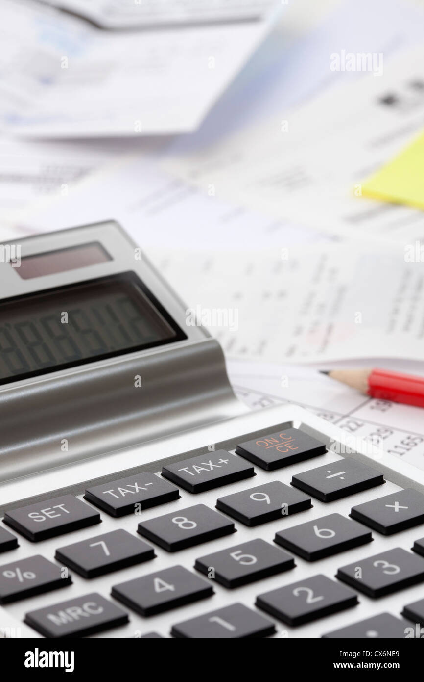 Ein Rechner auf ein Durcheinander von finanziellen Unterlagen Stockfoto