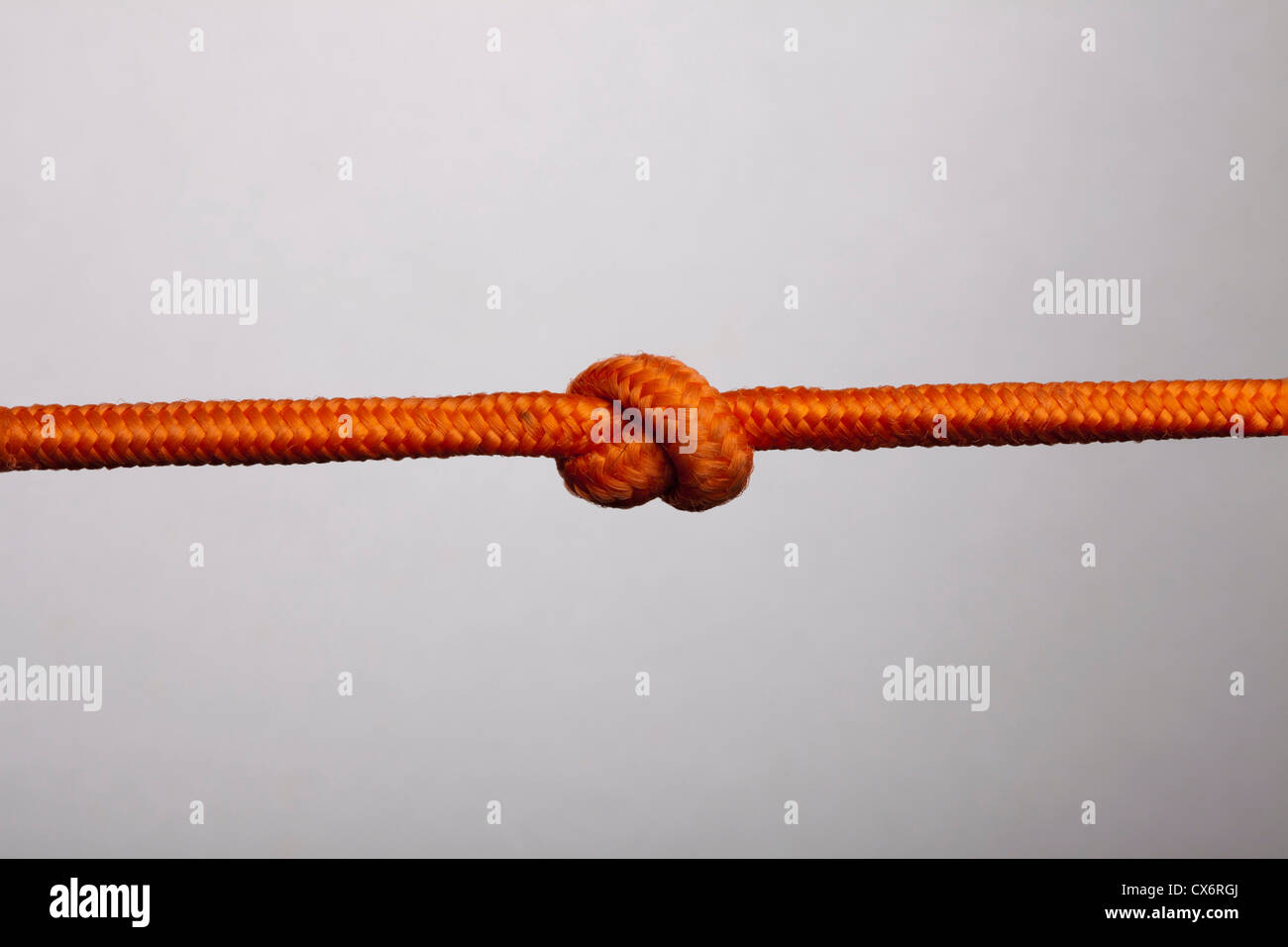 Eine orange Seil mit einem Knoten drin Stockfoto