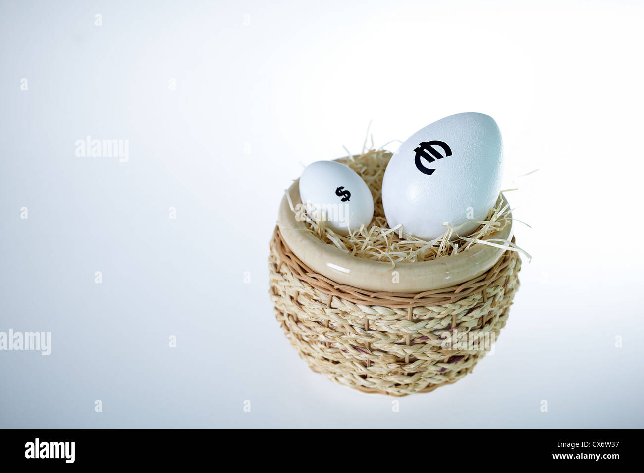 Bild der großen Ei mit Euro-Zeichen und kleineres mit Dollarzeichen im nest Stockfoto