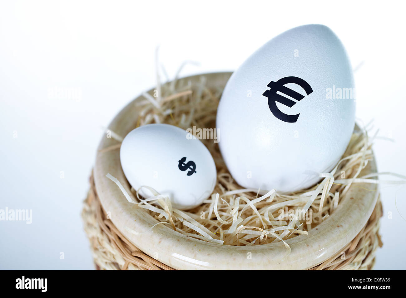 Bild der großen Ei mit Euro-Zeichen und kleineres mit Dollarzeichen im nest Stockfoto