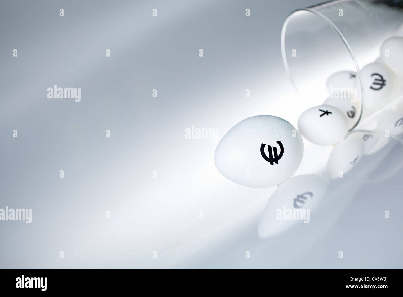 Bild des großen weißen Ei mit Euro-Zeichen und kleineren Eiern mit Währungszeichen hinter Stockfoto