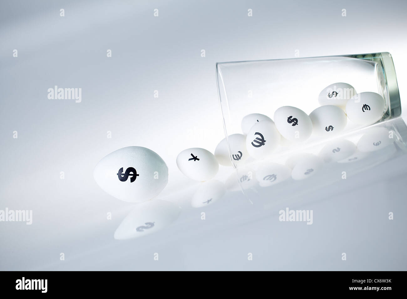 Bild des großen weißen Ei mit Dollarzeichen und kleineren Eiern mit Währungszeichen hinter Stockfoto