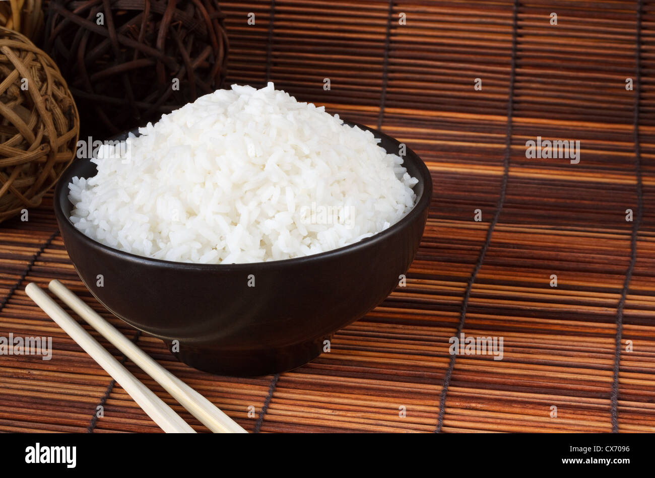 Schüssel mit gekochtem Reis eine populäre Begleitung mit orientalischen Speisen Stockfoto