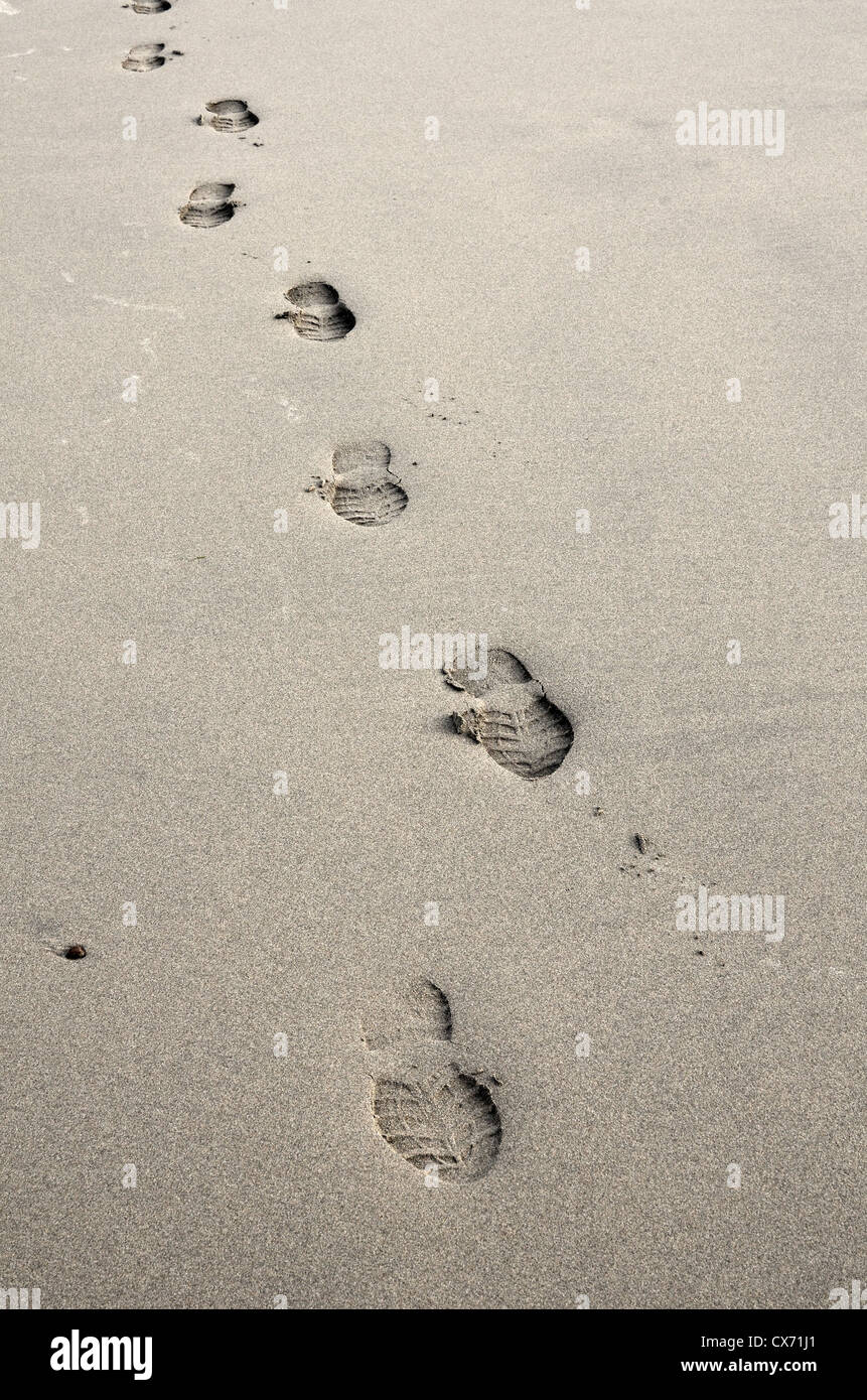 Konzept der menschlichen Aktivität - einsame Spur der menschlichen Fußabdrücke in feuchten Sand. Konzentrieren Sie sich mehr auf den Bereich um 2d & 3-Bilanz. Tracker fonds Metapher Stockfoto