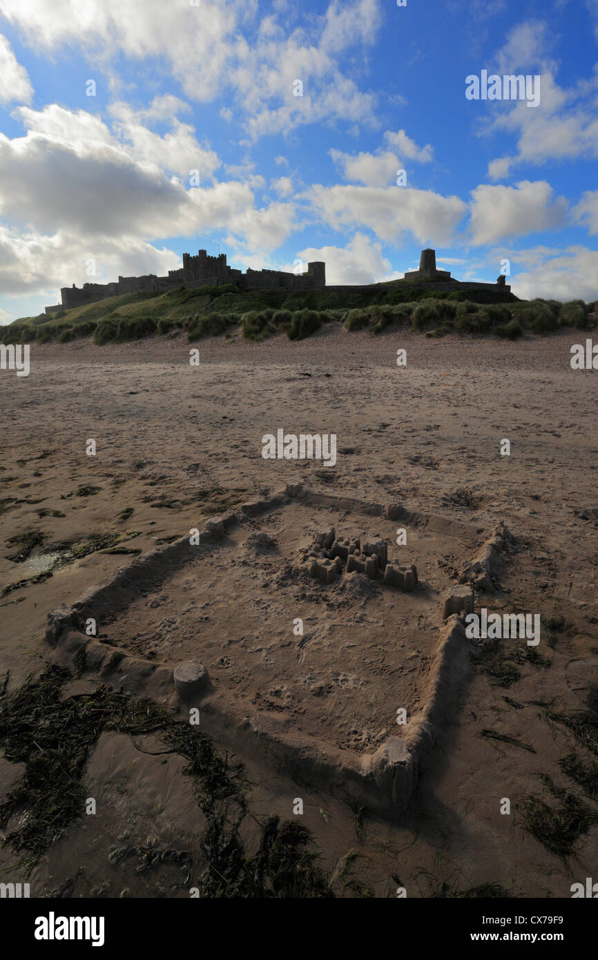 Bamburgh Castle in Northumberland mit einer Sandburg am Ufer im Vordergrund. Stockfoto