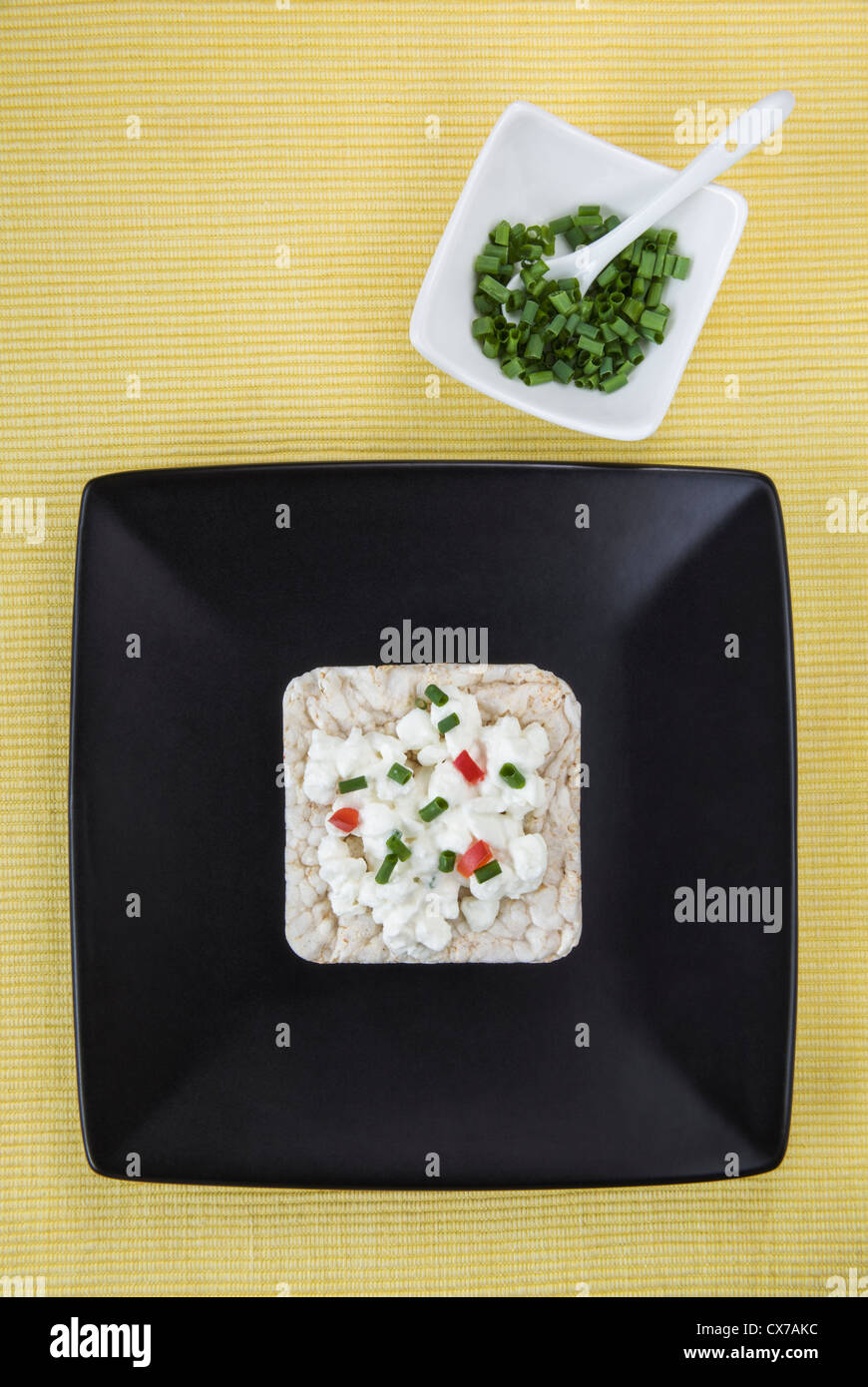 Reiskuchen mit Hüttenkäse auf schwarzen Druckplatte gekrönt Stockfoto