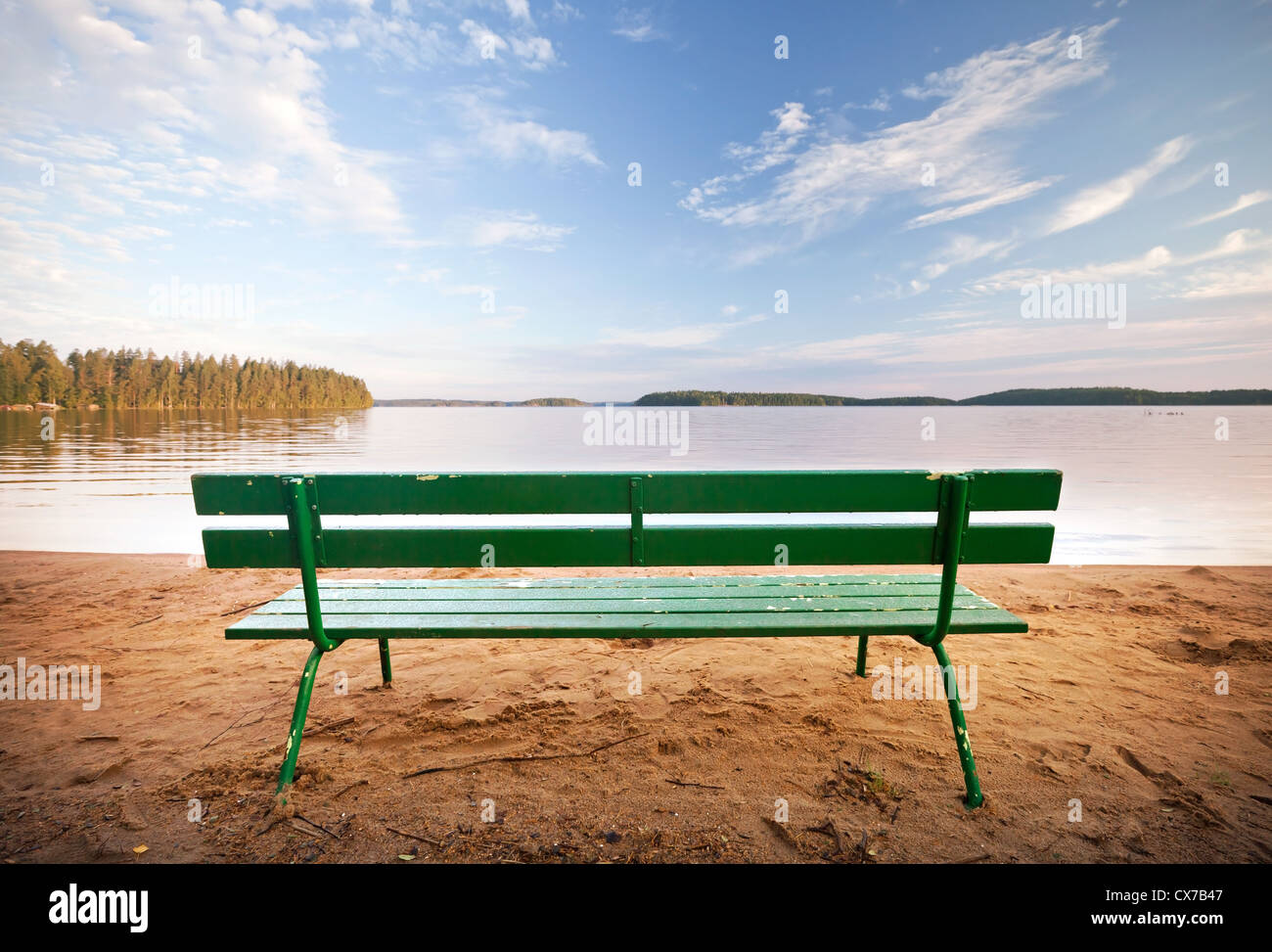 Grüne Holzbank vor der Küste von See Stockfoto