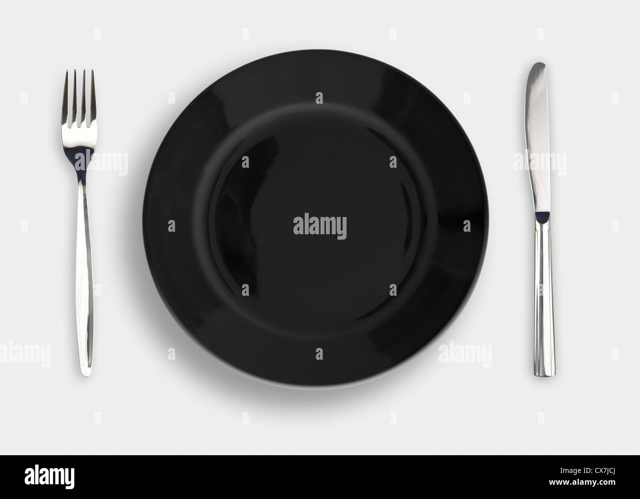 Weißen Teller, Messer und Gabel auf schwarzem Hintergrund Stockfoto