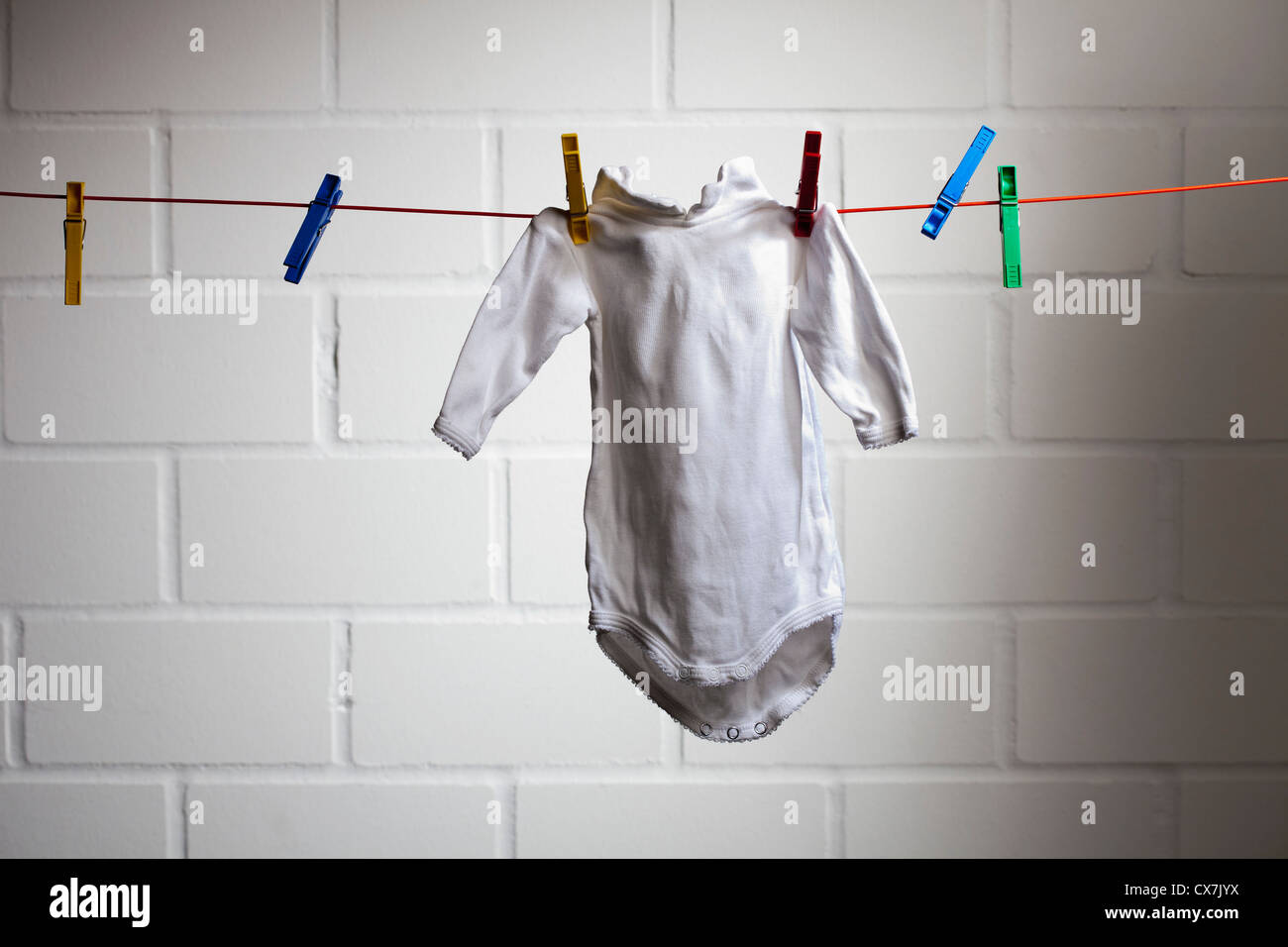 Ein Baby-Strampler von einer Wäscheleine hängen Stockfoto