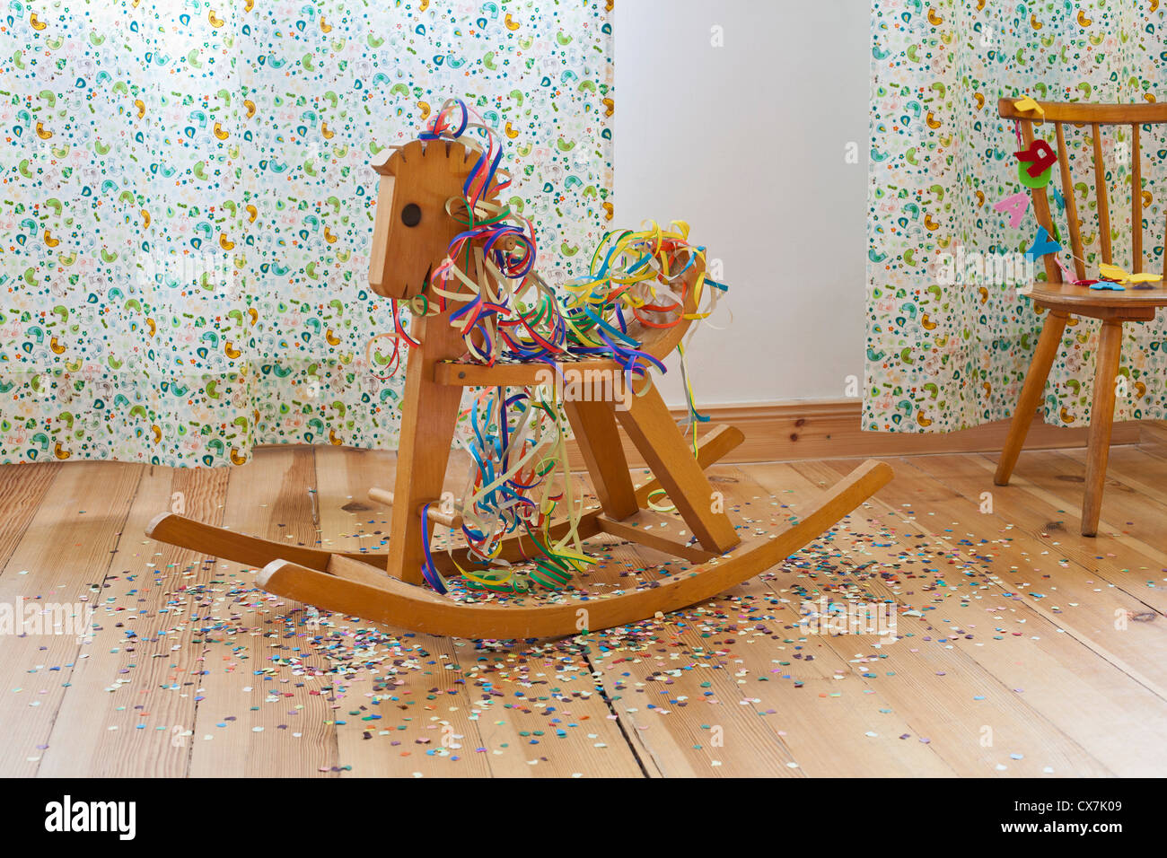 Ein Schaukelpferd Luftschlangen, Konfetti und alles Gute zum Geburtstagsbanner Stockfoto