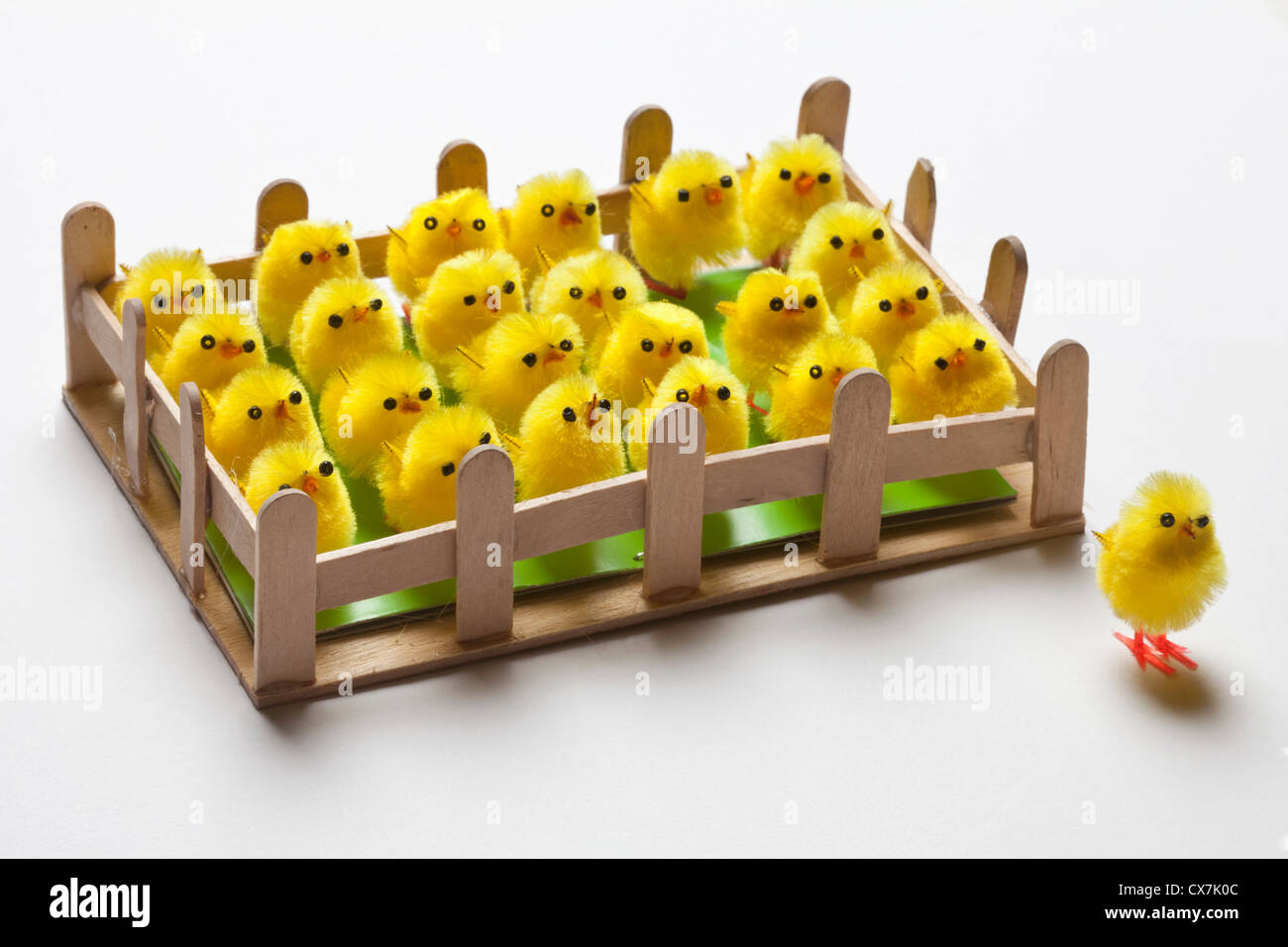 Eine Gruppe von Spielzeug Ostern Küken eingezäunt mit einem an der Außenseite des Zauns Stockfoto
