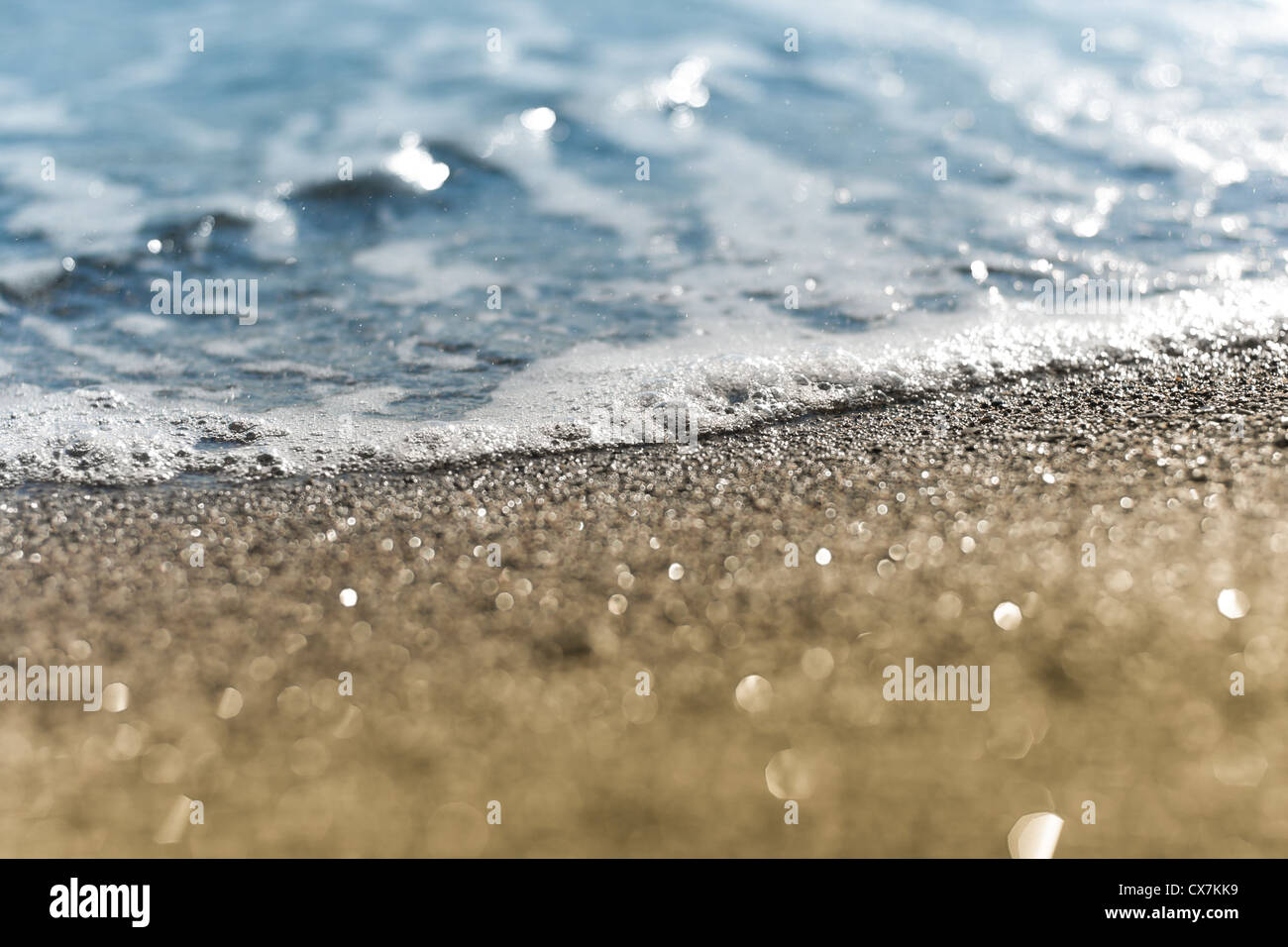 Sandstrand und Meer Schaum Makro mit engen Fokus Hintergrund Stockfoto