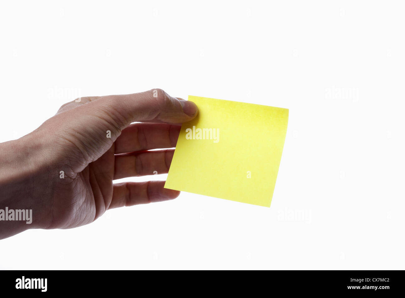 Ein Mann hält eine leere gelbe selbstklebende Notiz, close-up von hand Stockfoto