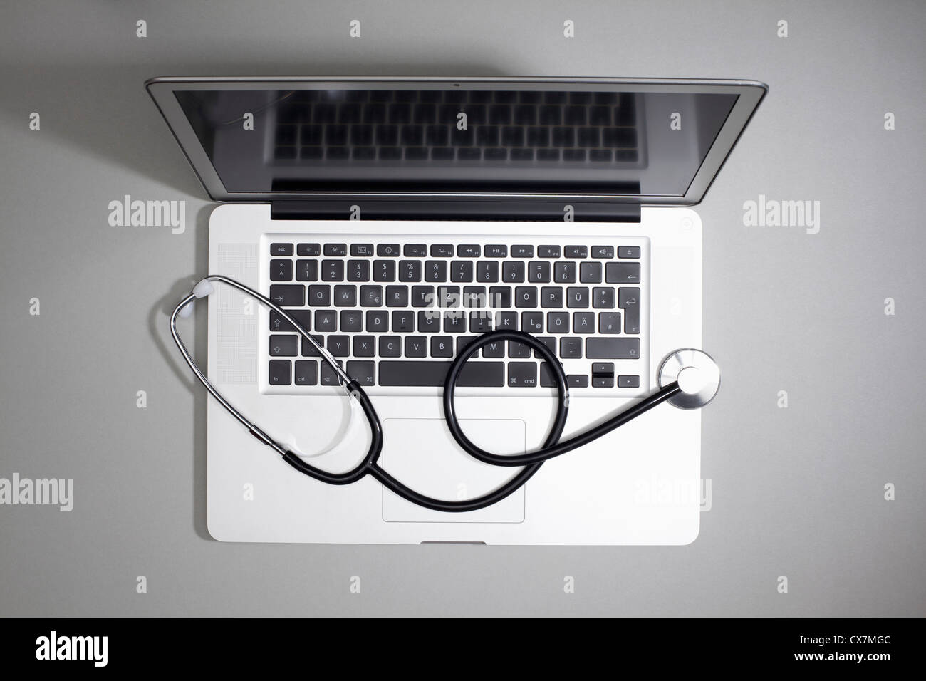 Ein Laptop mit einem Stethoskop oben drauf liegen Stockfoto