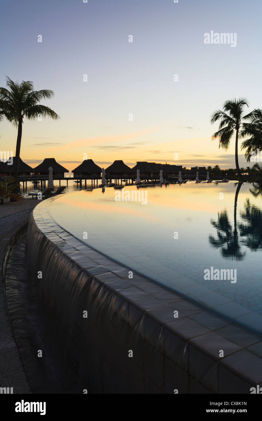 Sonnenuntergang und Palmen Bäume reflektiert in einem Pool im Bora Bora Nui Resort &amp; Spa; Insel Bora Bora, Französisch-Polynesien Stockfoto