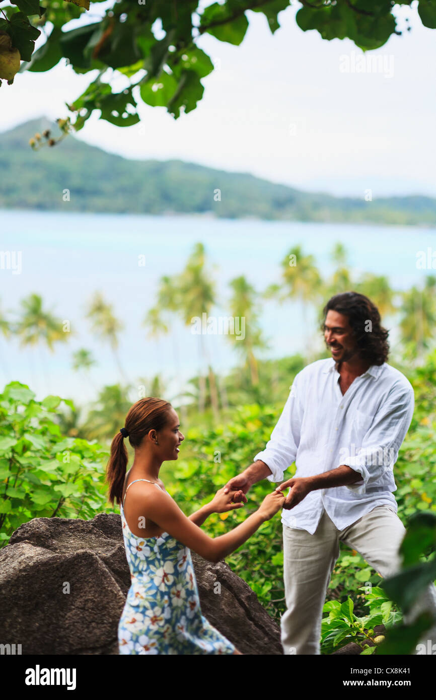 Halten Sie Hände mit Blick auf den Ozean auf Bora Bora Nui Resort &amp; Spa, ein Mann und eine Frau; Gesellschaftsinseln, Südpazifik Stockfoto