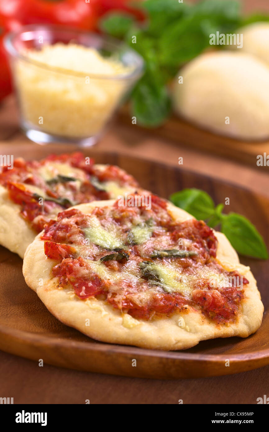 Knusprige hausgemachte Pizza Margherita oder Pizza Mozzarella (Pizza mit Tomaten, Basilikum und Käse) auf Holzplatte Stockfoto