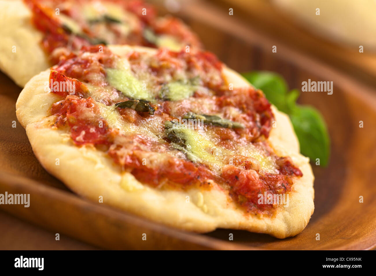 Knusprige hausgemachte Pizza Margherita oder Pizza Mozzarella (Pizza mit Tomaten, Basilikum und Käse) auf Holzplatte Stockfoto