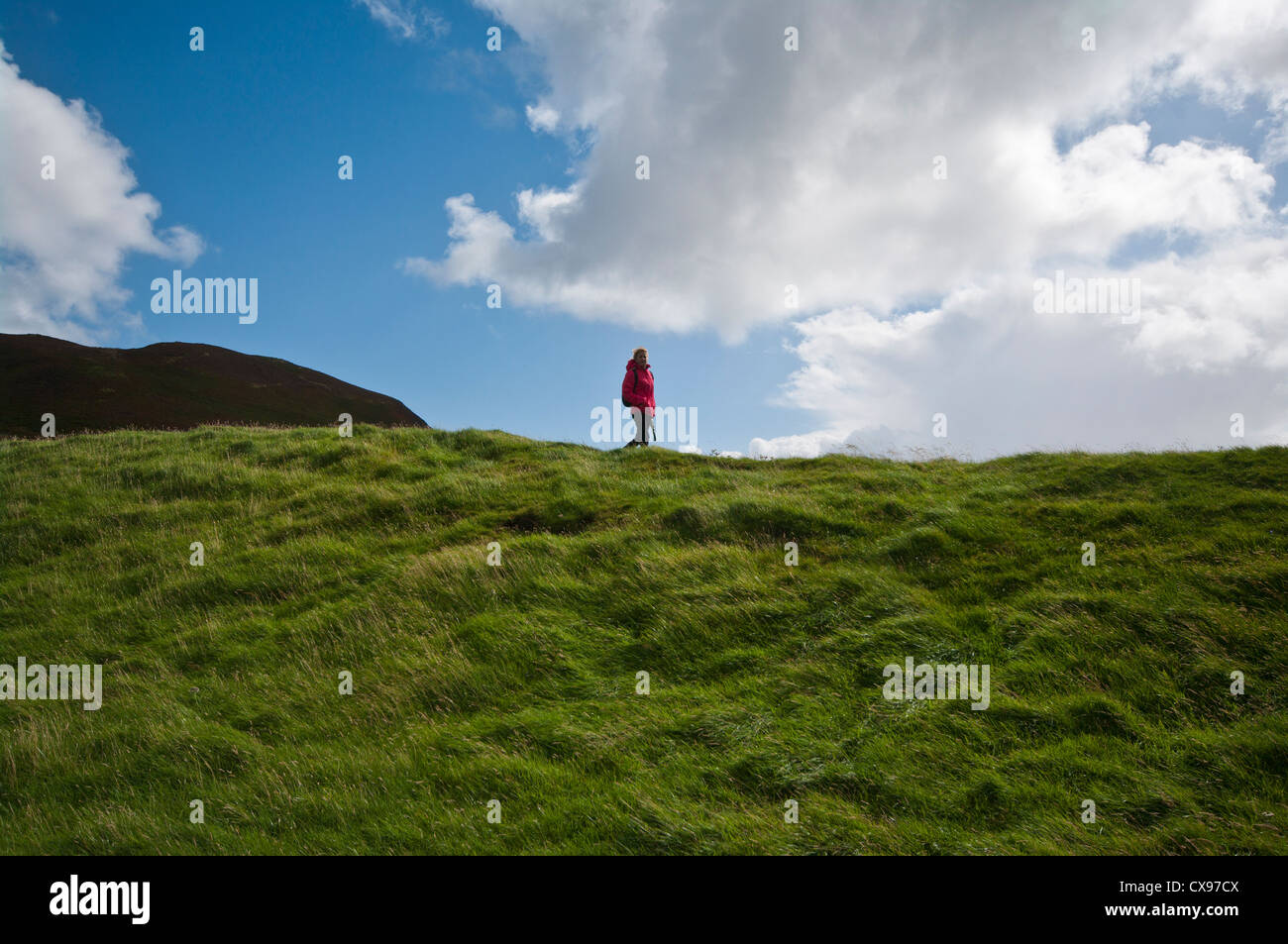 Vorderansicht einer Frau Person zu Fuß durch die Landschaft tragen wasserdichte Kleidung und Rucksack Stockfoto