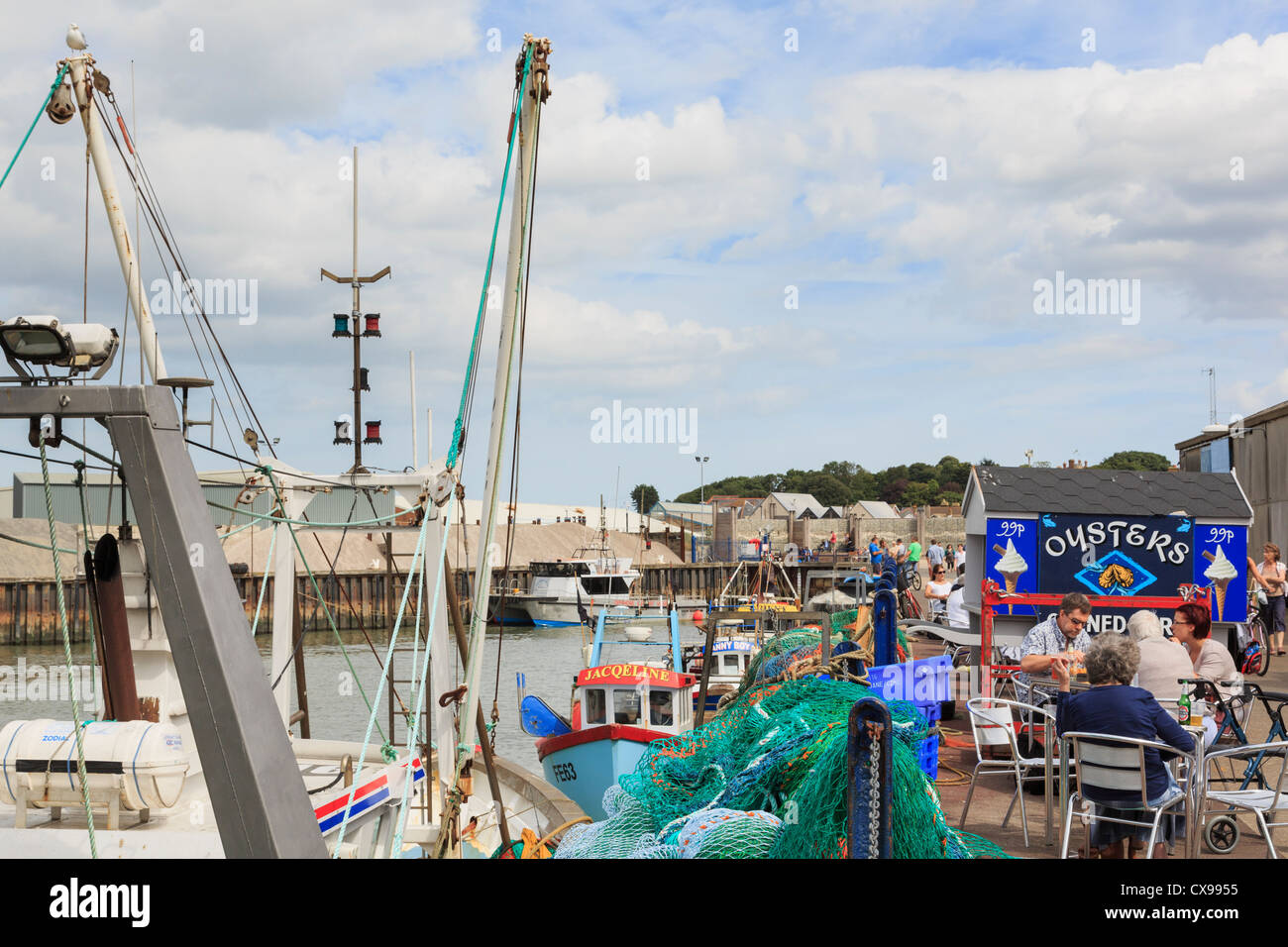 Whitstable Hafen-Szene mit Leuten, die Restaurants und Bars in der Oyster Bar am Kai auf North Kent und Themse-Mündung Küste in Whitstable Kent England UK Stockfoto