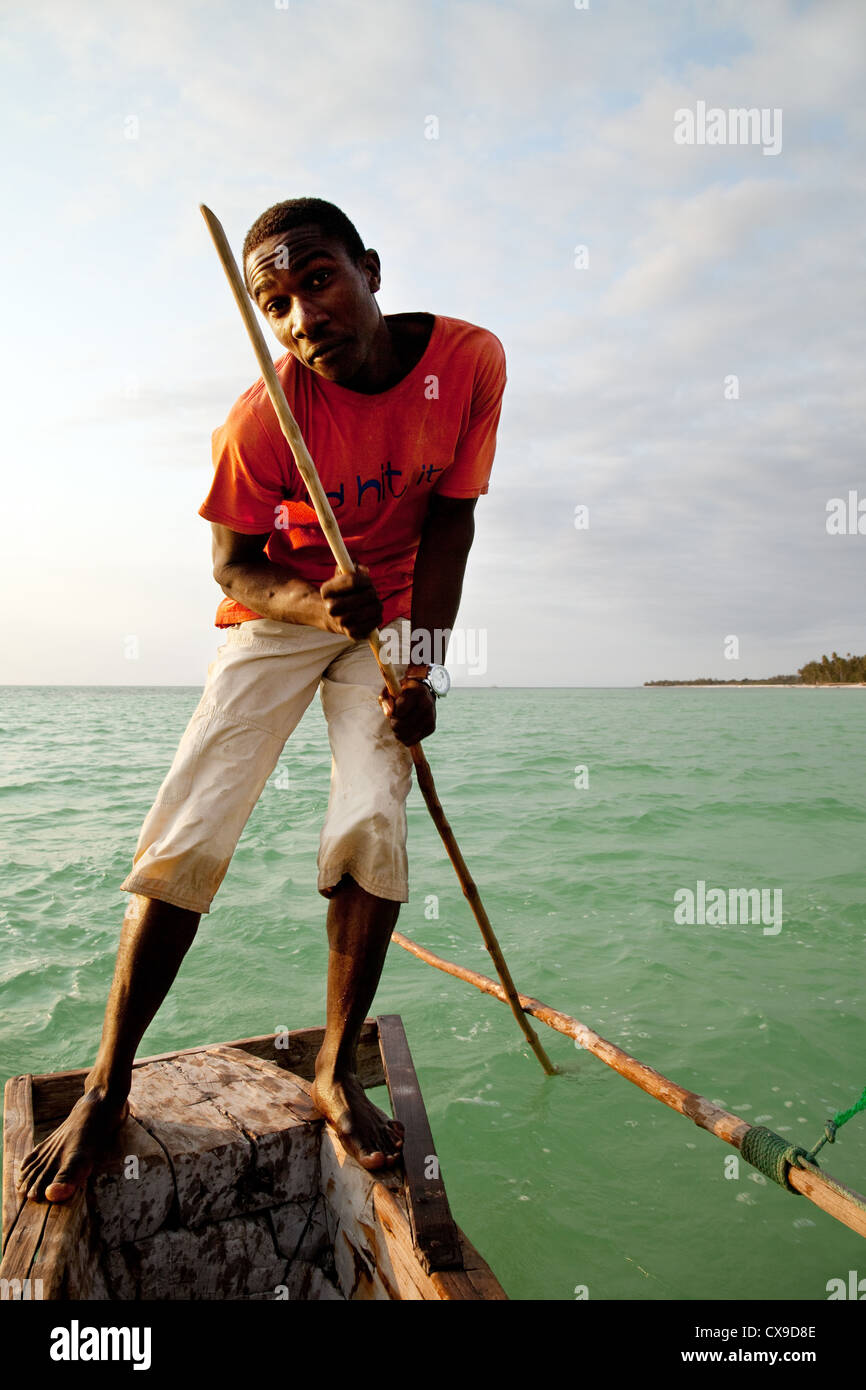 Young Zanzibari Mann poling einer traditionellen Dhau Sansibar Tansania Afrika Stockfoto