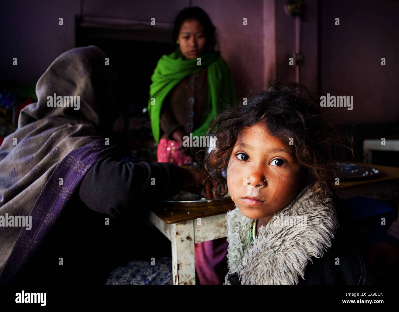 Armes Mädchen und ihre Familie Essen in einem schmutzigen Café in Kathmandu, Nepal Stockfoto