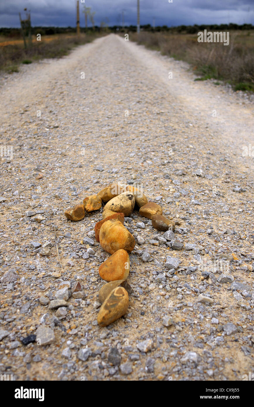 Ein Pfeil aus Kieselsteinen auf dem Camino weist den Weg nach Santiago De Compostela, Spanien. Stockfoto