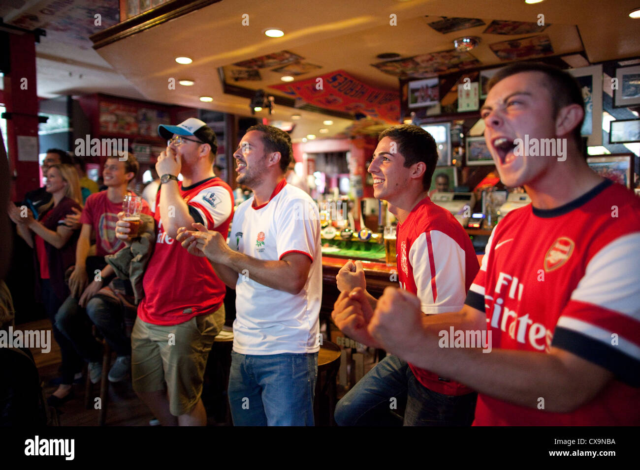 Arsenal-Fußball-Fans beobachten das Spiel im Fernsehen in der "Gunners" Pub Finsbury Park, Nord-London, am Spieltag. Stockfoto