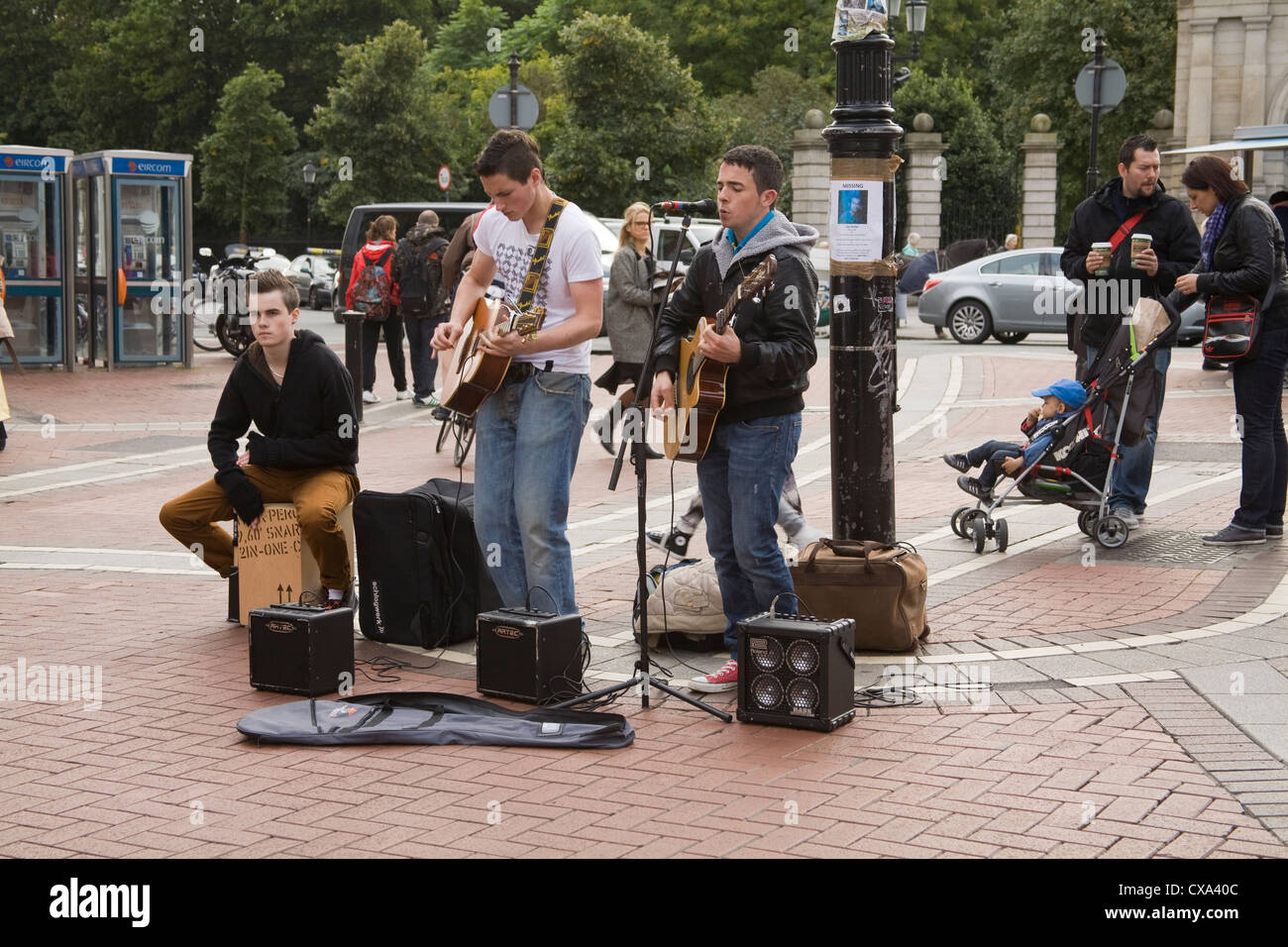 Dublin Stadt Eire EU drei junge männliche Buskers singen und spielen zu Massen auf den Straßen der Stadt Stockfoto
