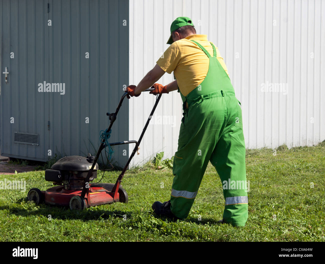 Rasenmäher-Mann arbeitet auf dem Hinterhof Stockfoto