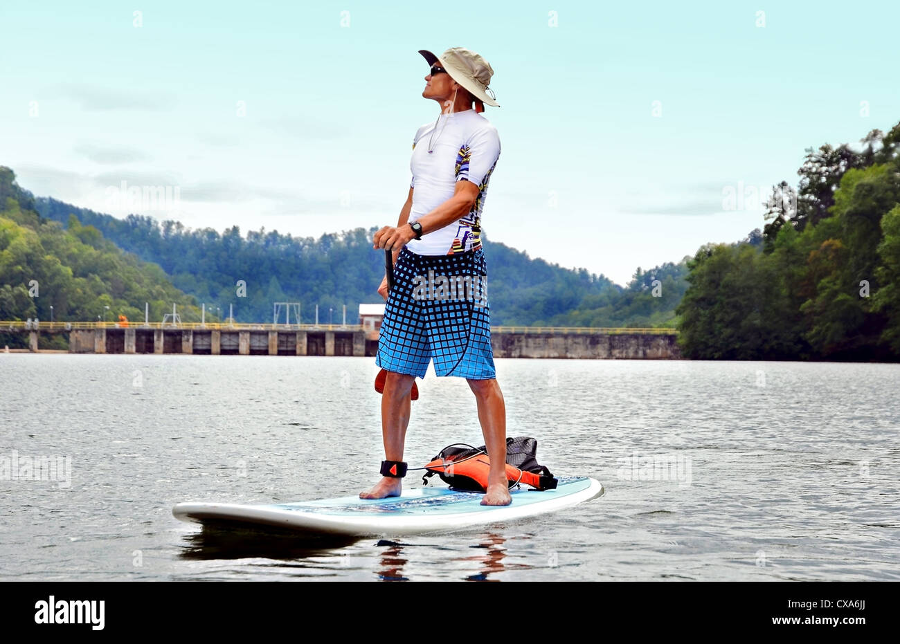 Ein Mann auf einem Paddle Board auf dem Damm des Sees. Stockfoto
