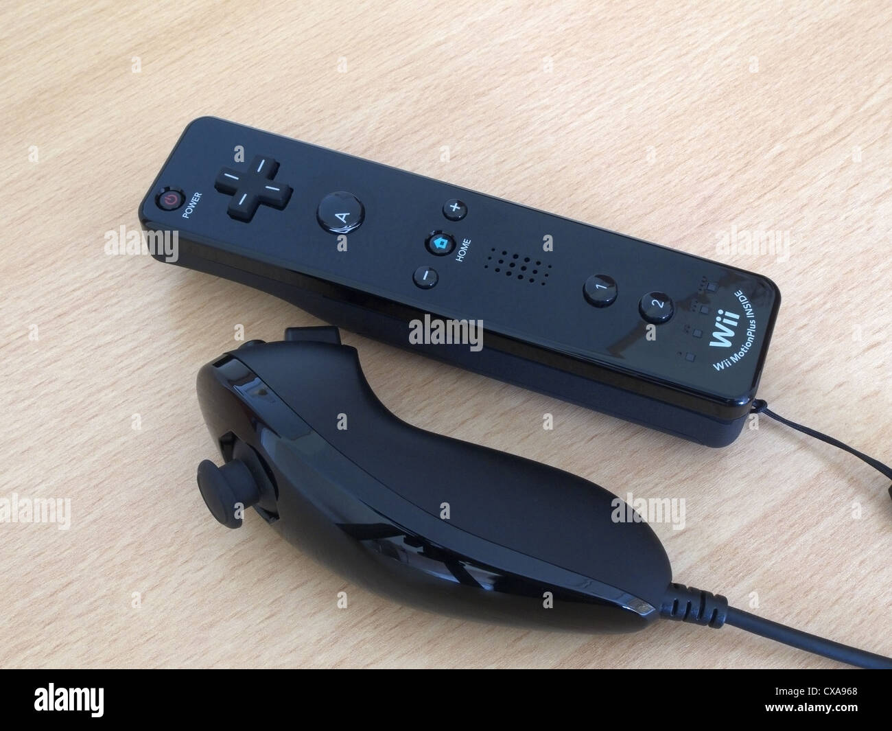 Nintendo Wii Remote und Nunchuck Controller Schwarz auf einer hölzernen Hintergrund Stockfoto