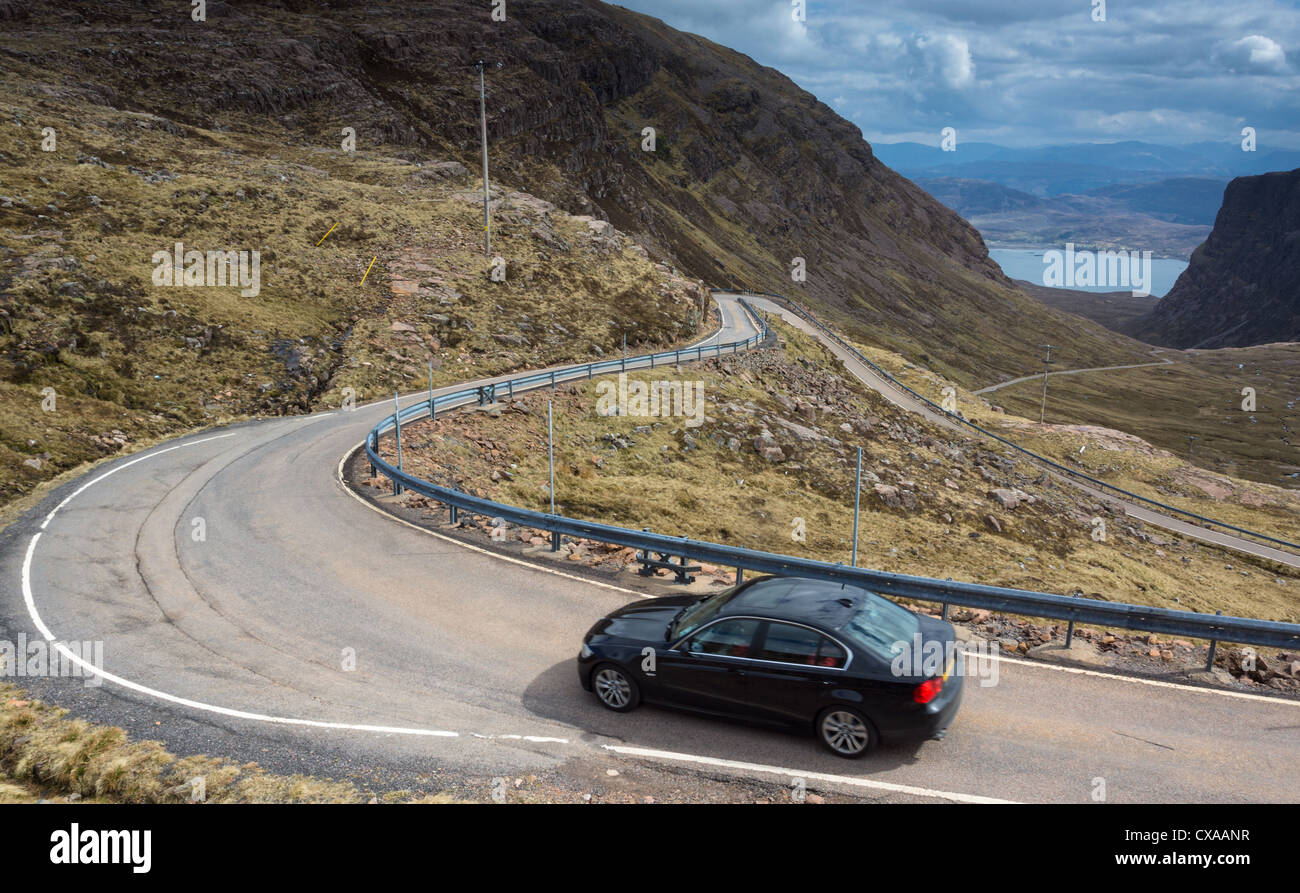 Ein Auto absteigend die kurvenreiche Straße führt, die Bealach Na Ba, Schottisches Hochland. Stockfoto