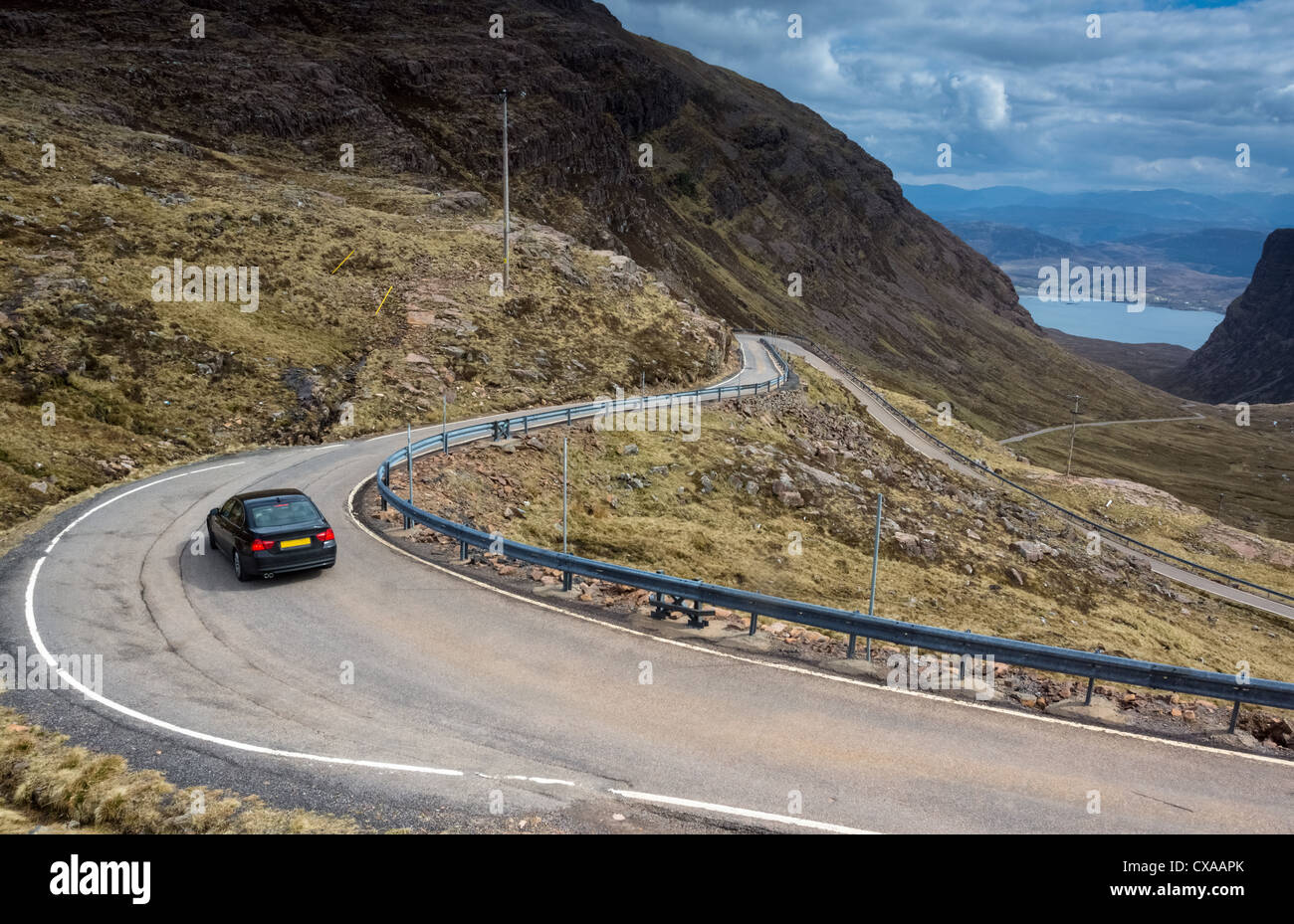 Ein Auto absteigend die kurvenreiche Straße führt, die Bealach Na Ba, Schottisches Hochland. Stockfoto