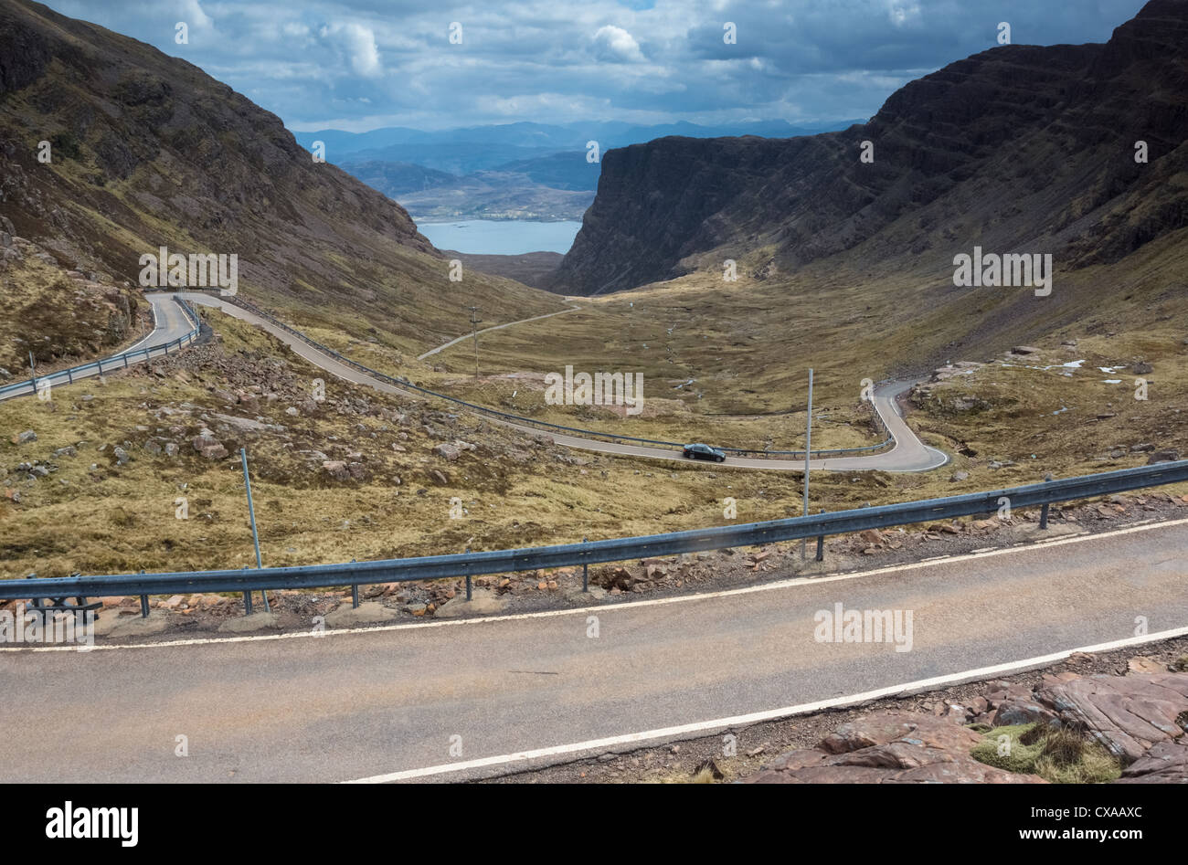 Ein Auto absteigend die kurvenreiche Straße führt, die Bealach Na Ba, Schottisches Hochland. Stockfoto