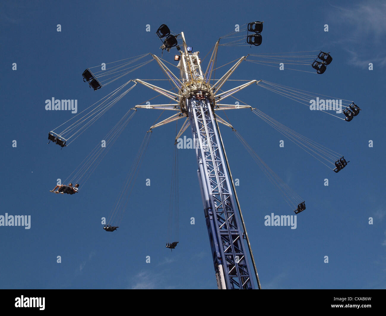 Hoch aufragende Kreisverkehr Fahrt mit ausgebreiteten drehbaren Sitze am North Greenwich vor blauem Himmel mit Wolkenfetzen Stockfoto