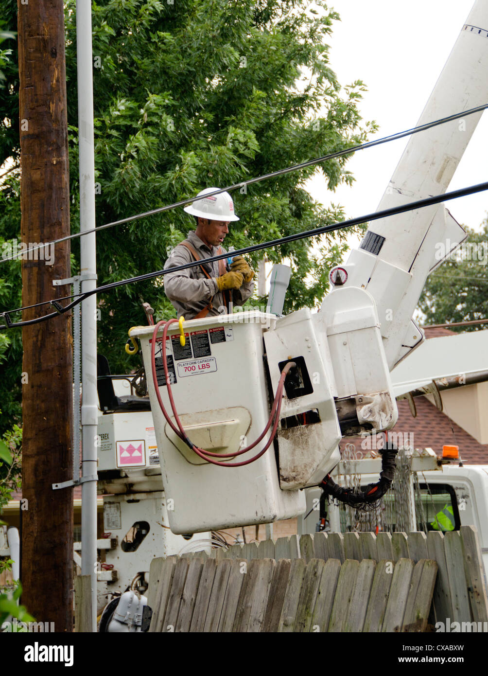 Ein Mann bei der Arbeit für eine elektrische Unternehmen in einem Lift Schaufel stoppt für einen Schluck Wasser, das bei der Installation eines neuen Strommast und Linien. Stockfoto