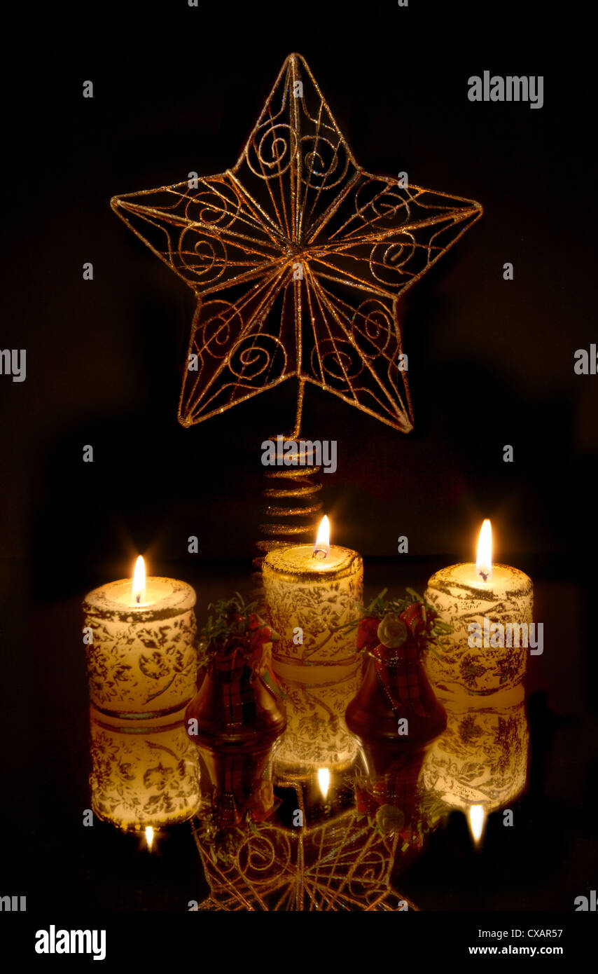 Weihnachtsstern mit drei Kerzen auf schwarz Stockfoto