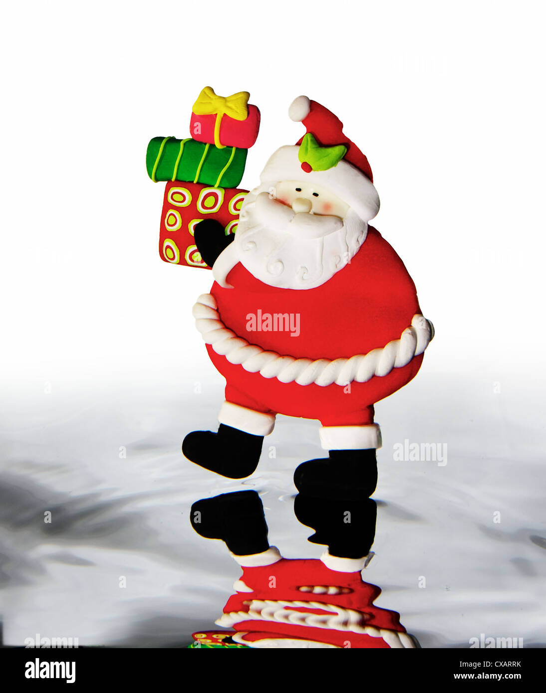 Santa Figur hält Geschenke, stehend auf dem Wasser Stockfoto