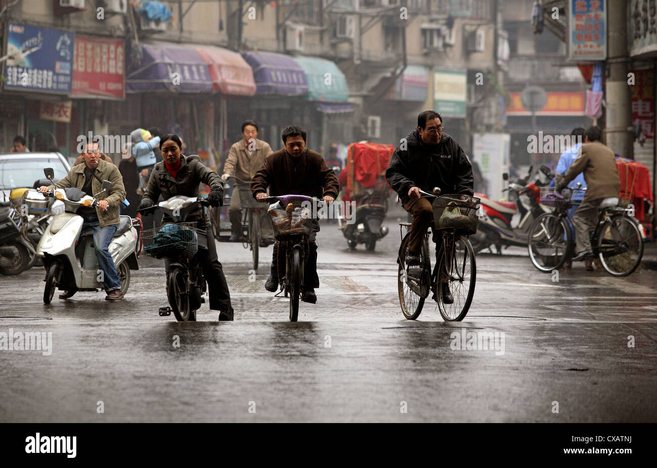 Shanghai, Radfahrer auf nasser Fahrbahn Stockfoto