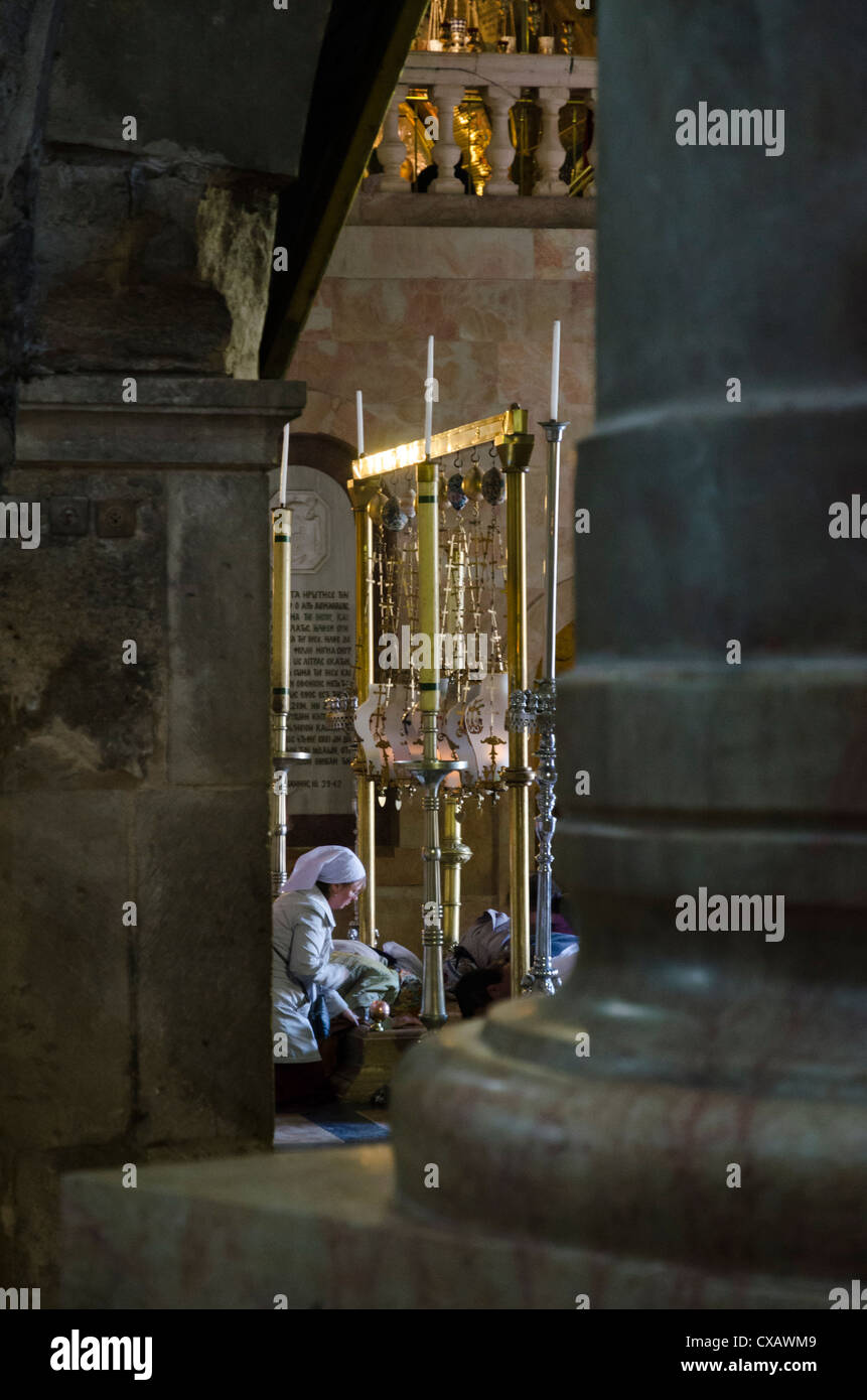 Weibliche Pilger niederwerfen auf den Stein der Salbung durch Säulen gesehen. Grabeskirche, Altstadt, Jerusalem, Israel Stockfoto
