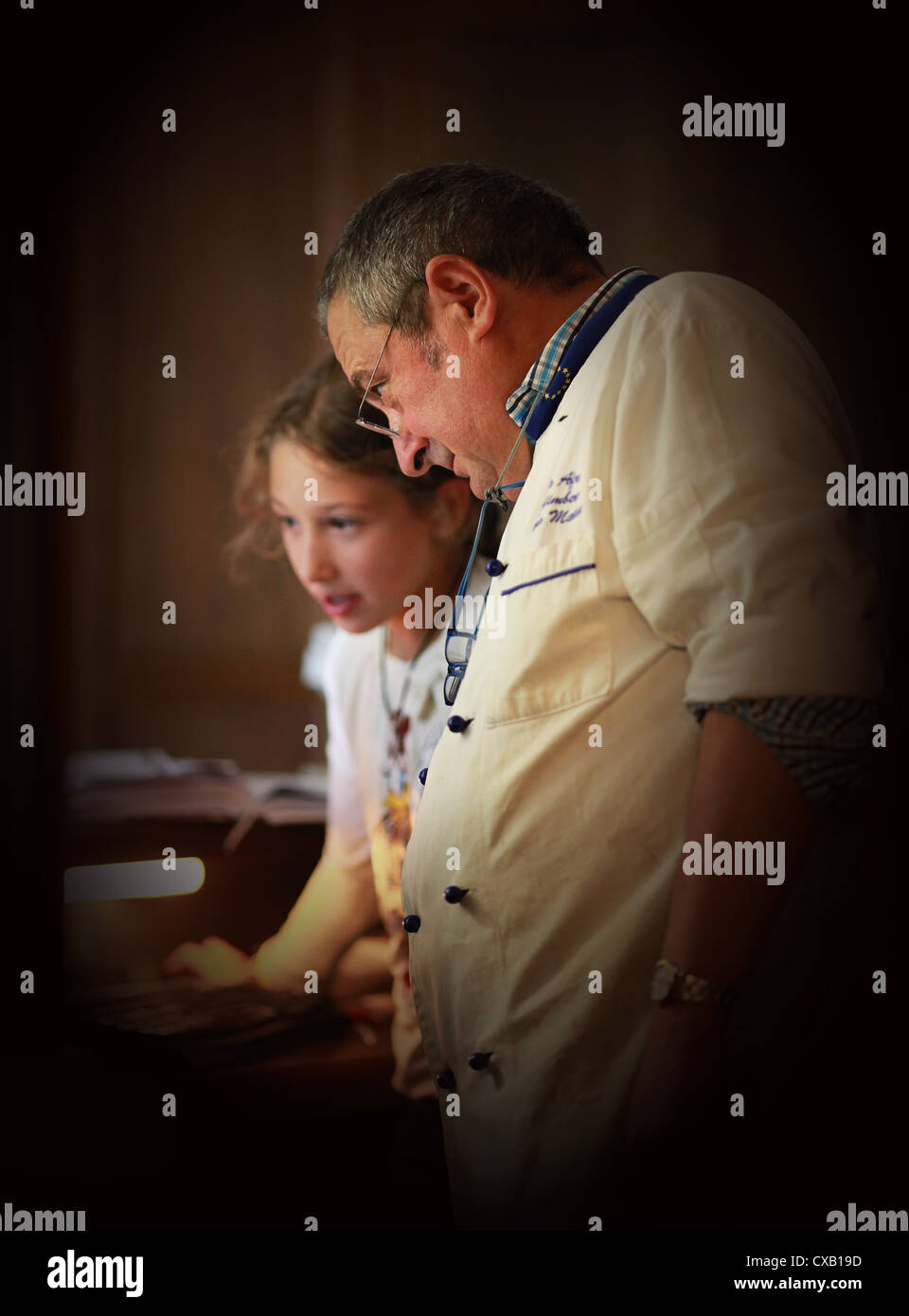 Ein Hotel und Restaurant Besitzer überprüfen mit seiner Tochter die Reservierung an der Rezeption. Spilimbergo, Norditalien. Stockfoto