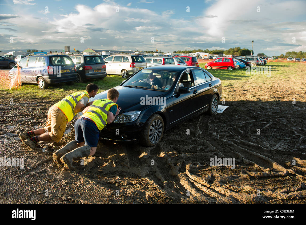 Freiwillige, die ein Auto im Schlamm stecken bei der Eisteddfod Genedlaethol Cymru 2012 / National Eisteddfod von Wales Stockfoto