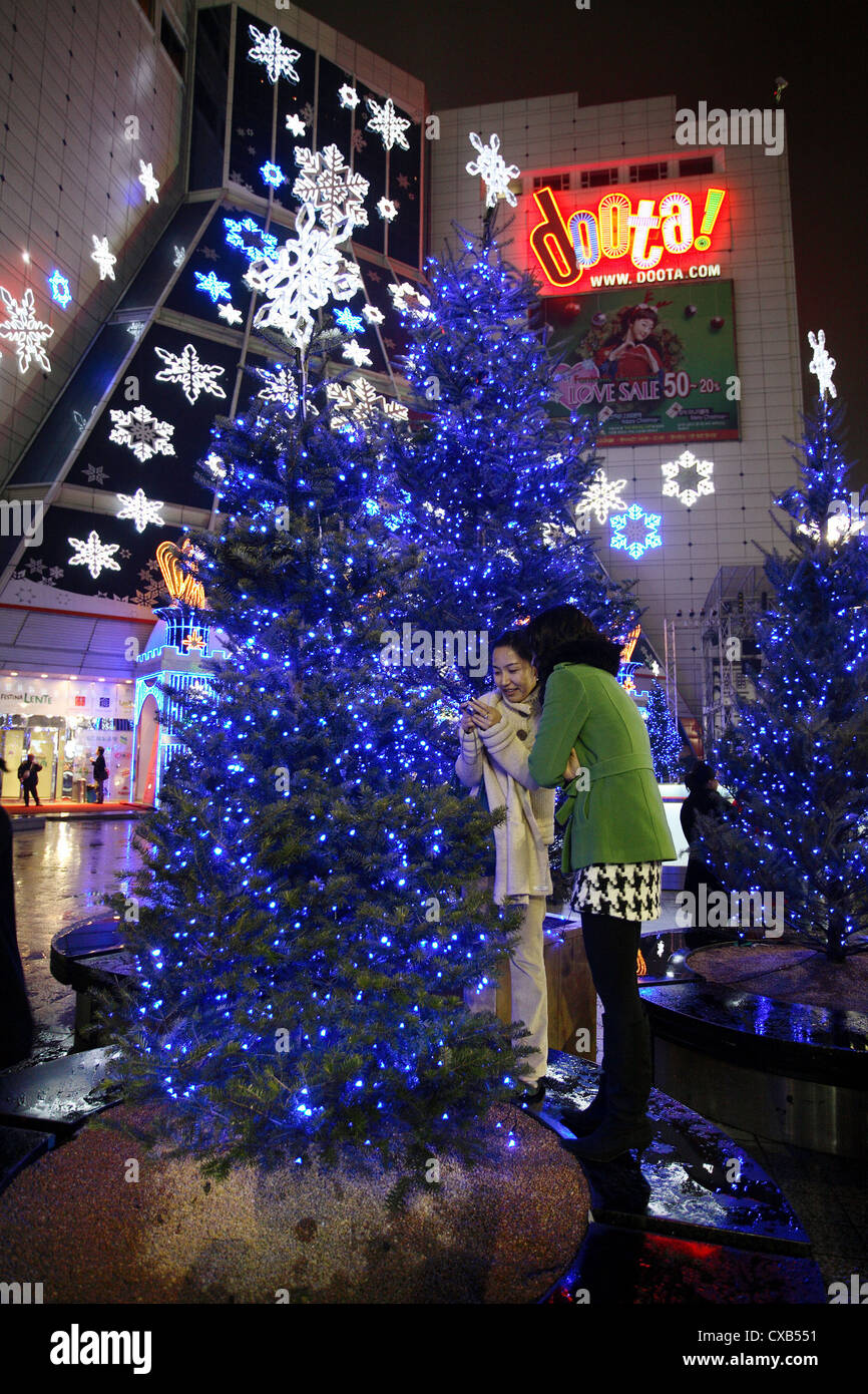 Seoul, Frauen vor einem blauen Weihnachtsbaum Stockfoto