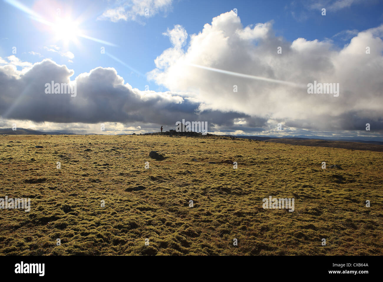 Gipfel-Cairn und Walker an der Spitze der Geal Charn einer der schottischen Mondadhliath Berge Stockfoto