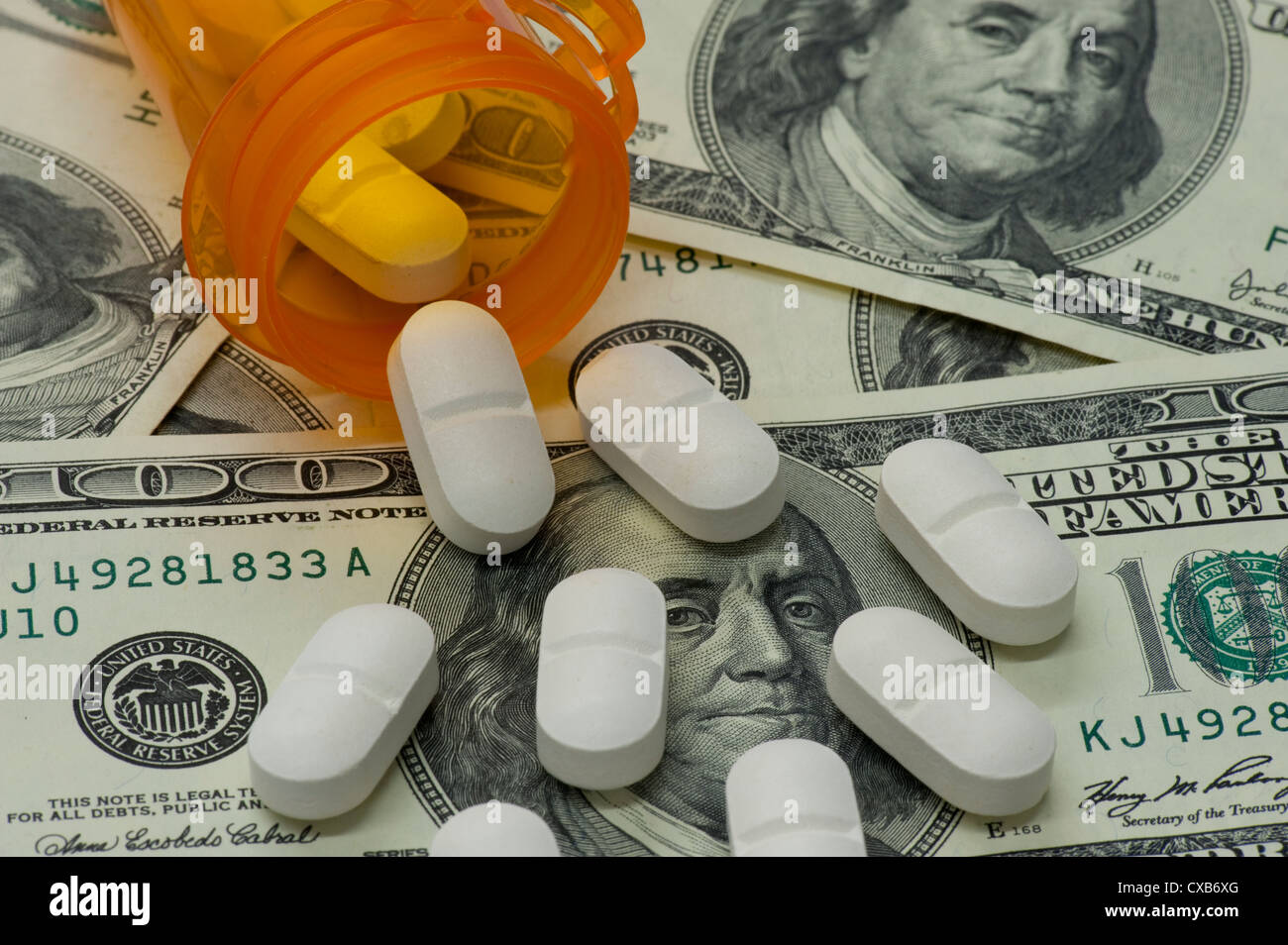 Pille-Flasche und Pillen auf mehrere $100-Dollar-Scheine Stockfoto