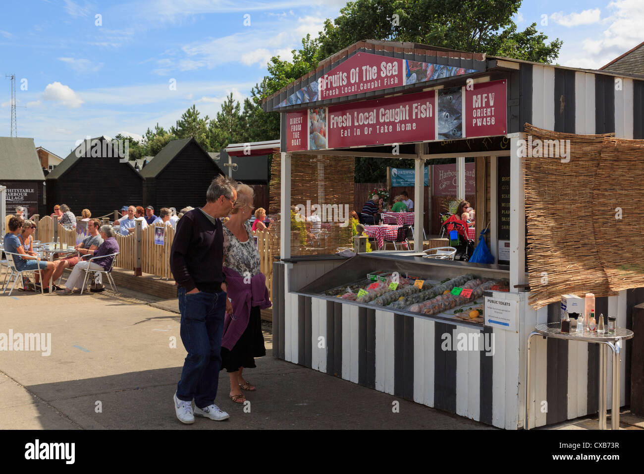 Menschen durch Meeresfrüchte Stall zu verkaufen lokale gefangen frische Muscheln auf Whitstable Fischerei Hafen Kai in Whitstable, Kent, England, UK, Großbritannien Stockfoto